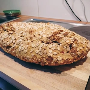 Brot bestreut mit Haferflocken auf einem Holzbrett