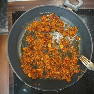 Haferhack angebraten in einer Pfanne mit Zwiebel und Möhren