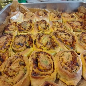 Fertig gebackene Pestoschnecken in Nahaufnahme. Durch das Aufgehen des Teiges sind die Schnecken einander gewachsen.